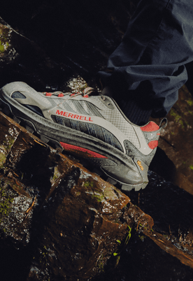 A hiker wearing waterproof Merrell shoes on a rocky trail.